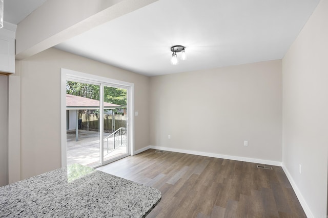 unfurnished dining area with wood finished floors and baseboards