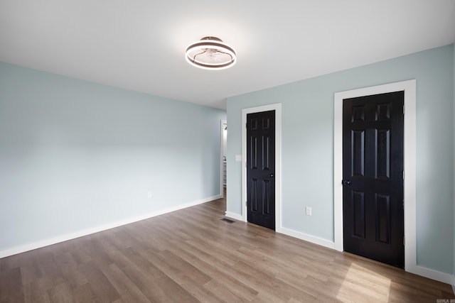 foyer entrance with wood finished floors and baseboards
