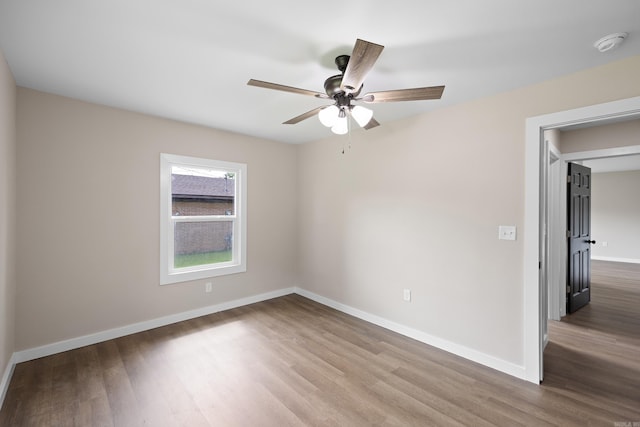 unfurnished room with wood finished floors, ceiling fan, baseboards, and a smoke detector