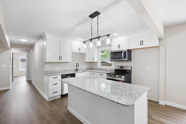 kitchen featuring stainless steel appliances, a sink, dark wood finished floors, a kitchen island, and white cabinets