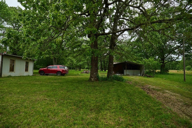 149 Firetower, Hardy, AR 72542 - view of green lawn featuring a carport and an outbuilding