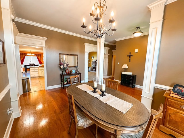 6 Palmer Ct, Searcy, AR 72143 - dining area with ornate columns, hardwood / wood-style floors, ornamental molding, baseboards, and a chandelier