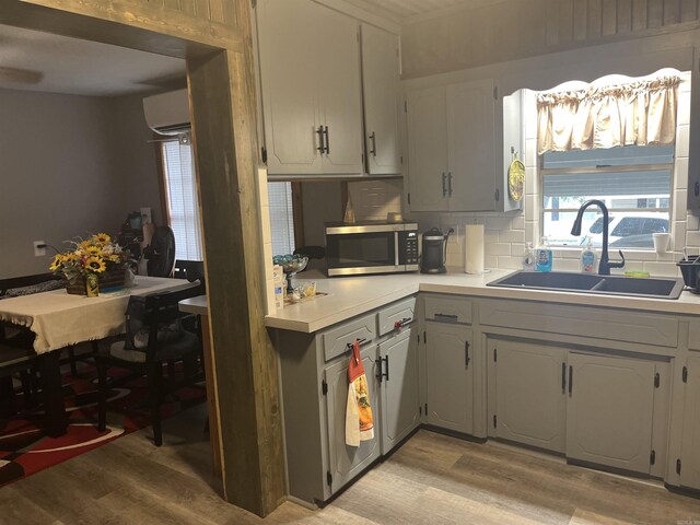1026 Wilson St, Malvern, AR 72104 - kitchen featuring light wood-type flooring, stainless steel microwave, a sink, and plenty of natural light