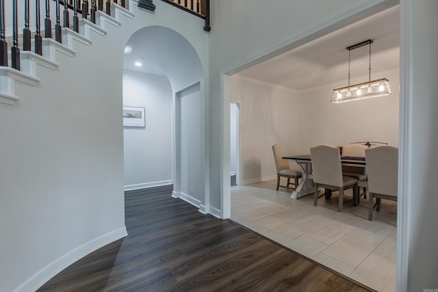 10 Silverwood Ct, North Little Rock, AR 72116 - dining space featuring arched walkways, dark wood-style floors, crown molding, and baseboards