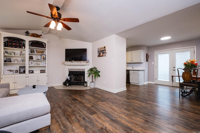 1520 Calgary Cv, Little Rock, AR 72211 - living room featuring a tile fireplace, vaulted ceiling, ceiling fan, dark wood-style flooring, and french doors