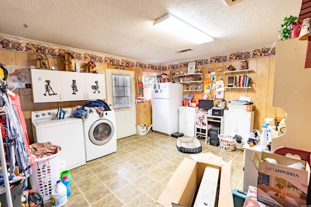 4531 Lee Road 225, Marianna, AR 72360 - laundry room featuring washer and clothes dryer, a textured ceiling, and wooden walls