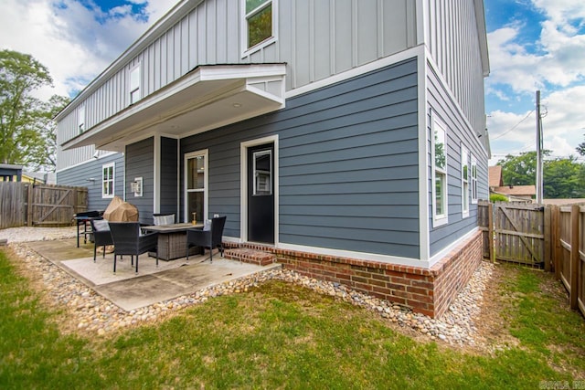 305 W Cross St, Benton, AR 72015 - rear view of house featuring board and batten siding, a gate, a patio, and a fenced backyard