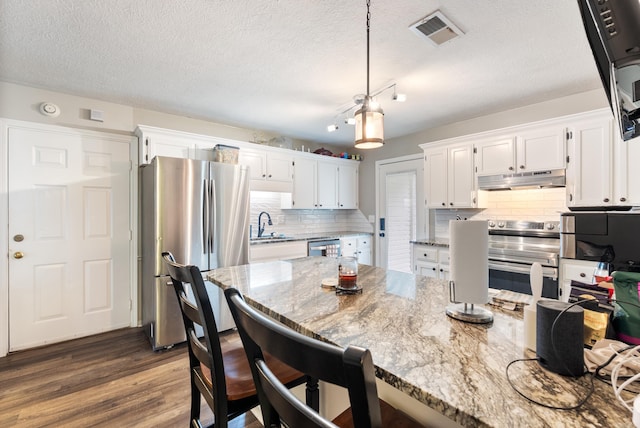 40 High Timber Dr, Maumelle, AR 72113 - kitchen featuring stainless steel appliances, under cabinet range hood, white cabinets, dark wood-type flooring, and light stone countertops