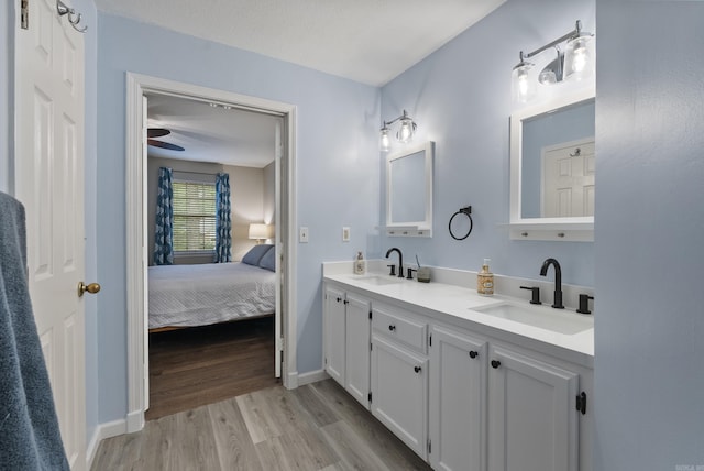 40 High Timber Dr, Maumelle, AR 72113 - ensuite bathroom featuring wood finished floors, baseboards, and double vanity