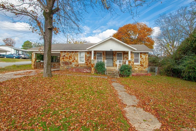1523 W 46, North Little Rock, AR 72118 - view of front facade featuring stone siding, a porch, an attached carport, and driveway