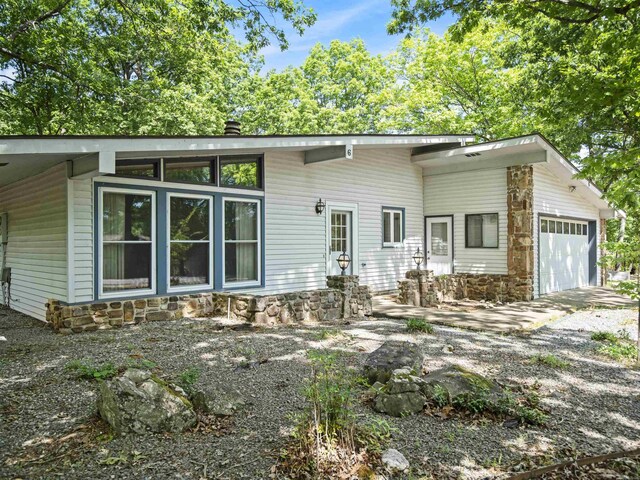 6 Sierra Ln, Hot Springs Village, AR 71909 - mid-century home with stone siding, an attached garage, and a chimney