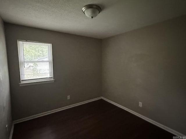 3509 Arapaho Trl, Little Rock, AR 72209 - empty room featuring baseboards, dark wood finished floors, and a textured ceiling