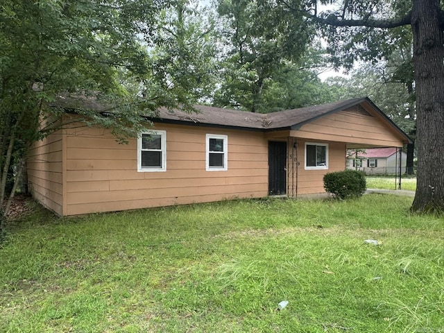 3509 Arapaho Trl, Little Rock, AR 72209 - back of house featuring a lawn and a carport
