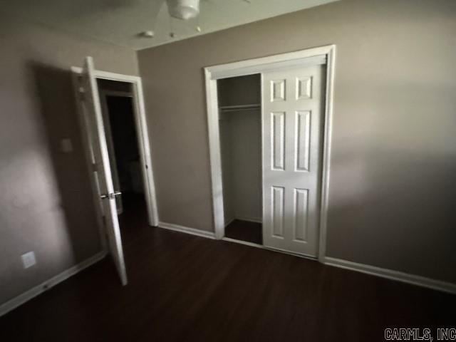 3509 Arapaho Trl, Little Rock, AR 72209 - unfurnished bedroom featuring dark wood-style flooring, baseboards, and a closet
