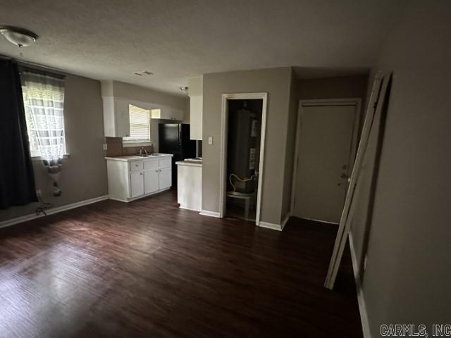 3509 Arapaho Trl, Little Rock, AR 72209 - unfurnished living room with dark wood-style floors and baseboards