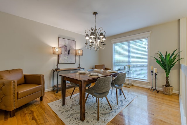 6220 Hopi Dr, North Little Rock, AR 72116 - dining space featuring a chandelier, baseboards, and light wood-style flooring
