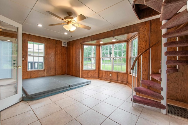 6220 Hopi Dr, North Little Rock, AR 72116 - workout area with wooden walls, ceiling fan, baseboards, light tile patterned floors, and crown molding