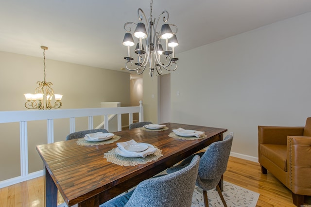 6220 Hopi Dr, North Little Rock, AR 72116 - dining room with a chandelier, light wood-style floors, and baseboards