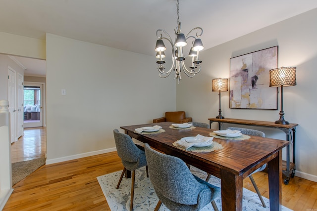 6220 Hopi Dr, North Little Rock, AR 72116 - dining space featuring light wood-style flooring, a chandelier, and baseboards