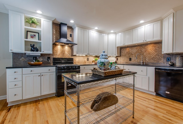 6220 Hopi Dr, North Little Rock, AR 72116 - kitchen with wall chimney range hood, black appliances, a sink, light wood-style floors, and recessed lighting