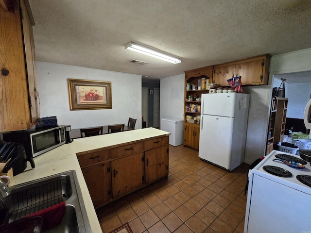 1020 Pioneer Rd, Searcy, AR 72143 - kitchen featuring white appliances, light countertops, a peninsula, a textured ceiling, and brown cabinetry