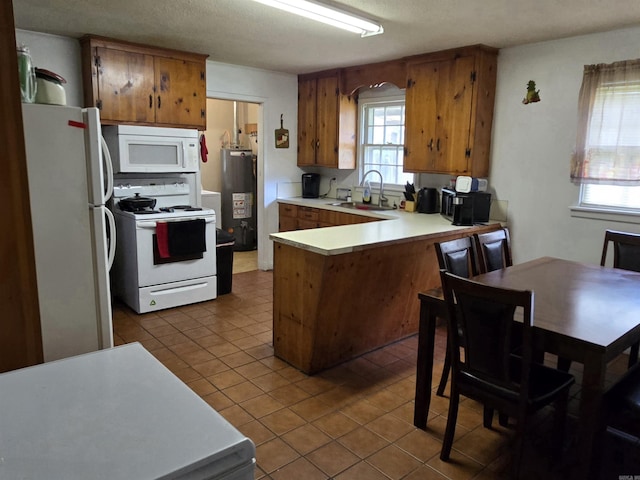 1020 Pioneer Rd, Searcy, AR 72143 - kitchen with white appliances, a sink, gas water heater, a peninsula, and brown cabinets