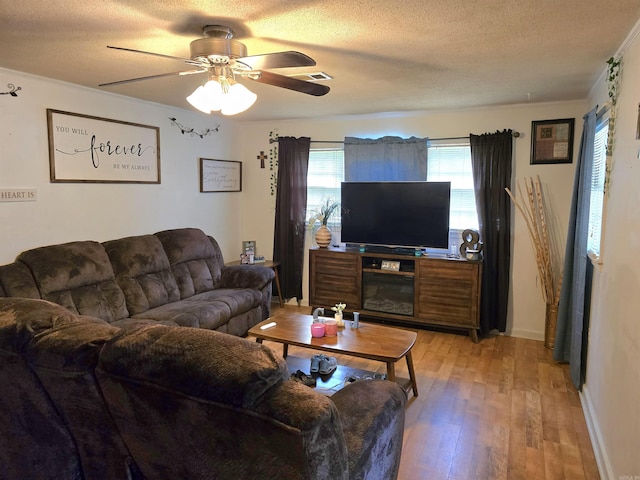 1020 Pioneer Rd, Searcy, AR 72143 - living area featuring a textured ceiling, a ceiling fan, light wood-style flooring, crown molding, and baseboards