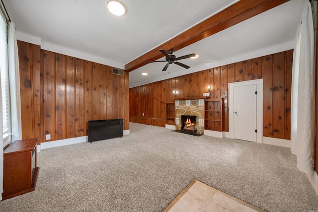 169 Crest St, Hot Springs, AR 71901 - unfurnished living room featuring ceiling fan, wood walls, a stone fireplace, carpet flooring, and beam ceiling