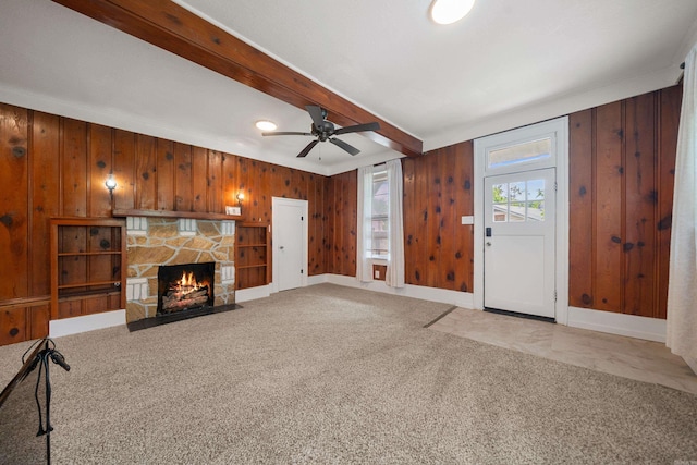 169 Crest St, Hot Springs, AR 71901 - unfurnished living room with wooden walls, a fireplace, ceiling fan, light carpet, and beam ceiling
