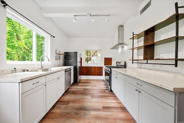 169 Crest St, Hot Springs, AR 71901 - kitchen featuring appliances with stainless steel finishes, wall chimney range hood, open shelves, a sink, and light wood-type flooring