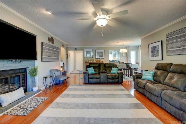 1201 Airport Rd Unit C12, Hot Springs, AR 71913 - living room with a textured ceiling, a ceiling fan, ornamental molding, wood finished floors, and a fireplace
