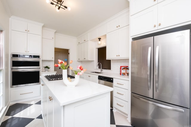 3501 Oakwood Rd Unit 9, Little Rock, AR 72202 - kitchen with stainless steel appliances, a sink, decorative backsplash, a center island, and light countertops