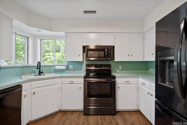 9425 Hogue Rd, Mabelvale, AR 72103 - kitchen with appliances with stainless steel finishes, a sink, light countertops, and white cabinets