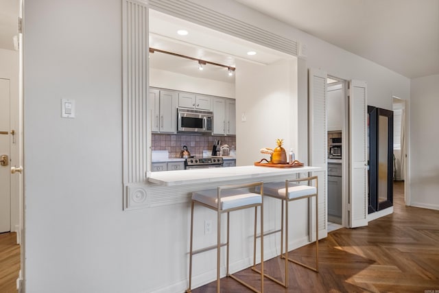 740 Weston Rd Unit 512-C, Hot Springs, AR 71913 - kitchen with appliances with stainless steel finishes, a kitchen bar, decorative backsplash, gray cabinets, and light countertops