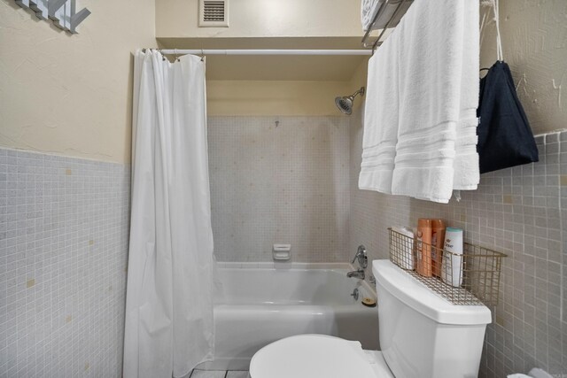 740 Weston Rd Unit 512-C, Hot Springs, AR 71913 - bathroom featuring tile walls, toilet, shower / bath combo, and wainscoting