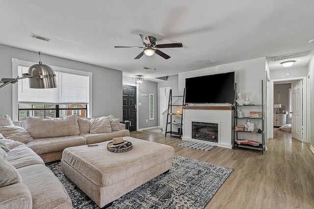 1301 Golf Crse, Jonesboro, AR 72404 - living area with wood finished floors, ceiling fan, baseboards, and a fireplace with flush hearth