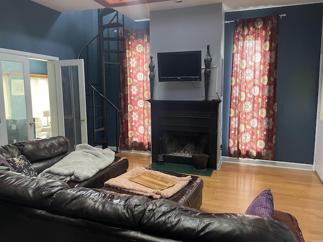 1349 Kahoka Rd, Mountain View, AR 72560 - living area featuring wood finished floors, a fireplace with flush hearth, french doors, baseboards, and stairway