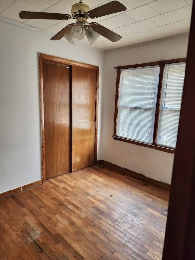 1206 S Main St, Leachville, AR 72438 - unfurnished bedroom featuring a closet, wood finished floors, ornamental molding, and a ceiling fan