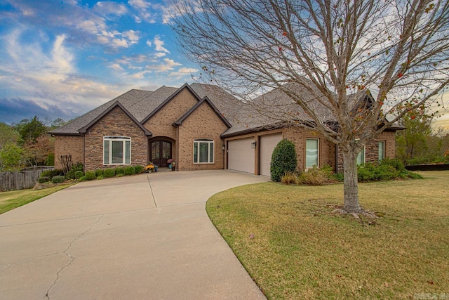 9021 Naples Cv, Benton, AR 72019 - french country style house featuring a garage, concrete driveway, a front lawn, brick siding, and french doors
