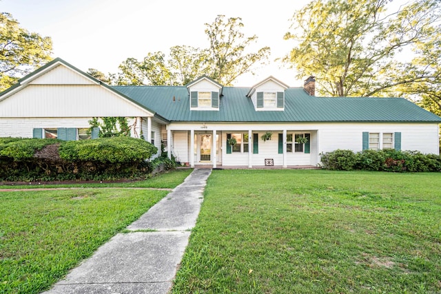 1002 N Bradley Ave, El Dorado, AR 71730 - cape cod-style house with a chimney, a front lawn, metal roof, and a porch