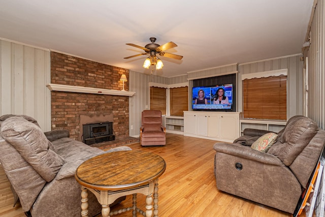 1002 N Bradley Ave, El Dorado, AR 71730 - living area featuring a wood stove, wood finished floors, ceiling fan, and ornamental molding