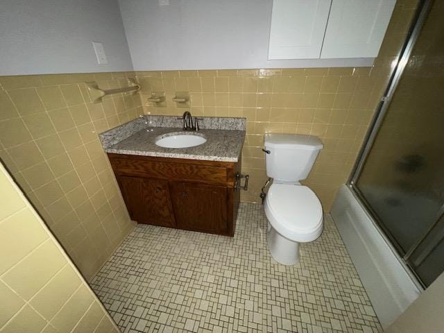 2308 Shoshoni Dr, Jonesboro, AR 72401 - full bath with tile walls, toilet, vanity, and bath / shower combo with glass door
