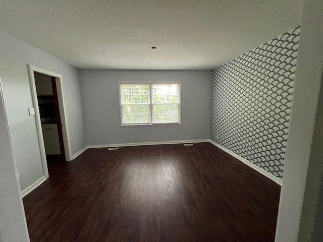 2308 Shoshoni Dr, Jonesboro, AR 72401 - unfurnished room with baseboards and dark wood finished floors