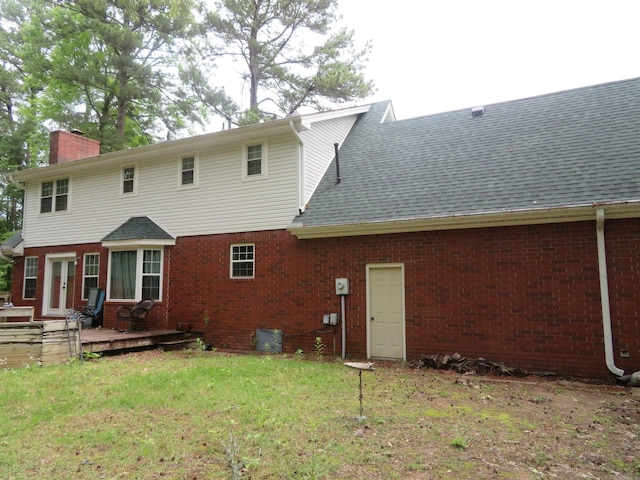 807 N Park Dr, Arkadelphia, AR 71923 - rear view of property featuring a chimney, brick siding, a wooden deck, a yard, and roof with shingles