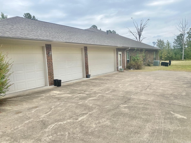 334 Grant 190009, White Hall, AR 71602 - view of side of home featuring brick siding, concrete driveway, roof with shingles, central air condition unit, and a garage