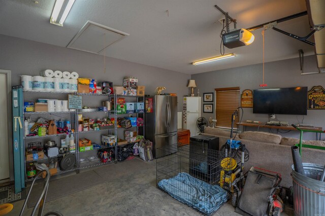 766 Mango Loop, Austin, AR 72007 - garage with freestanding refrigerator and a garage door opener