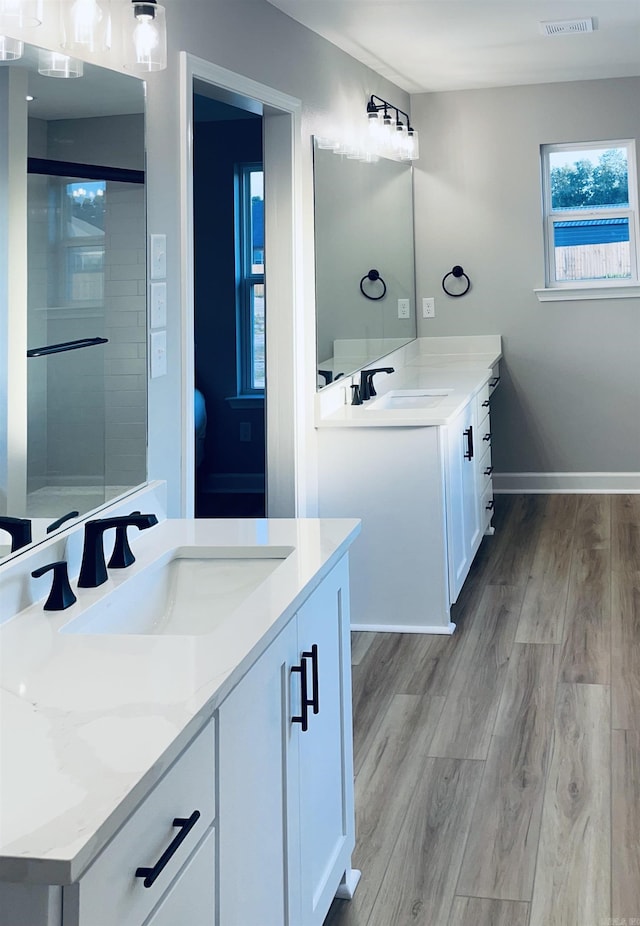 2033 Kaysen Ln, Hensley, AR 72065 - bathroom with two vanities, wood finished floors, and baseboards