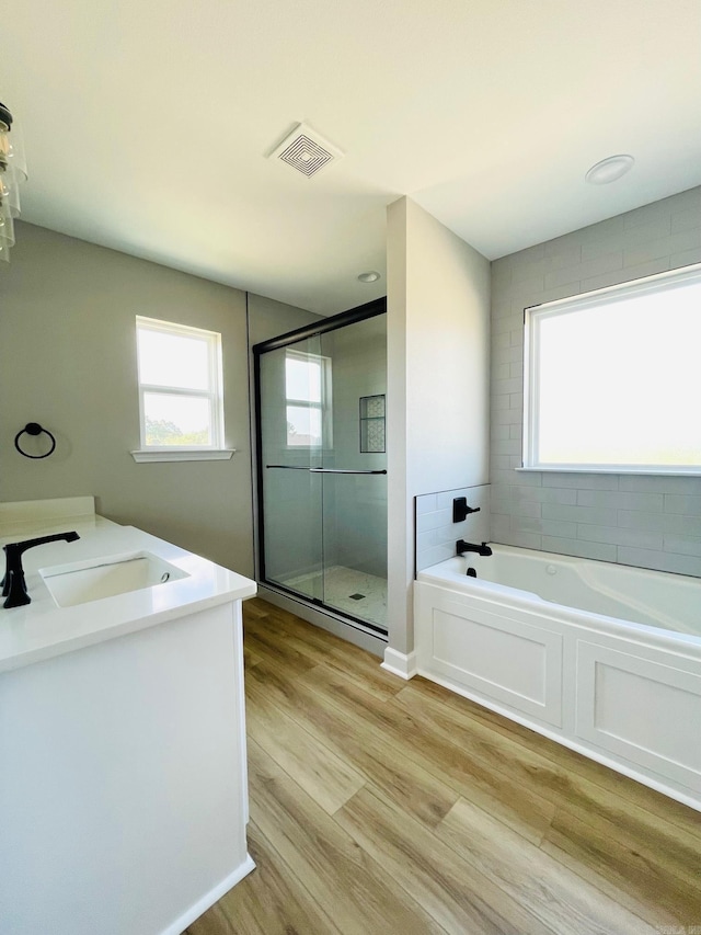 2033 Kaysen Ln, Hensley, AR 72065 - bathroom with a shower stall, a bath, vanity, and wood finished floors