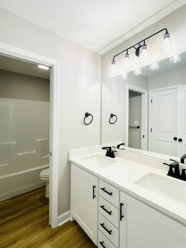 2033 Kaysen Ln, Hensley, AR 72065 - full bathroom with double vanity, wood finished floors, toilet, and baseboards
