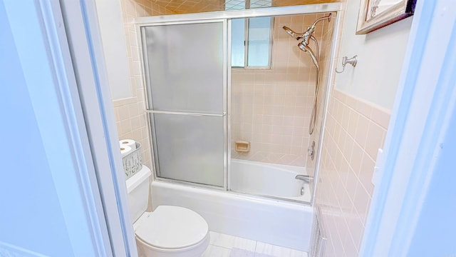 38 Wolfe, Mcgehee, AR 71654 - bathroom featuring toilet, tile walls, and combined bath / shower with glass door